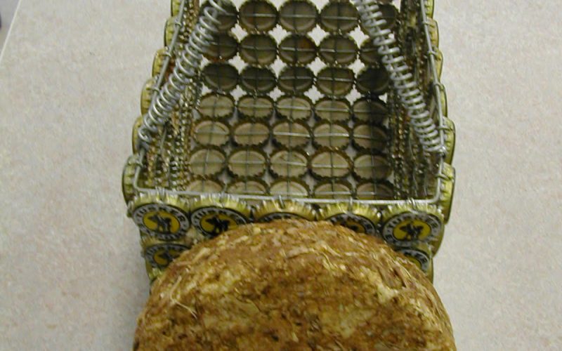 HEEED HANDICRAFTS products : Organic fuel briquette placed in front of a bottle-top basket.